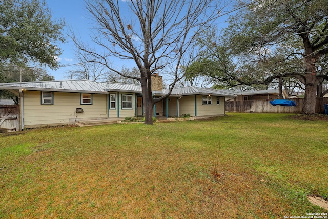 rear view of house featuring a yard