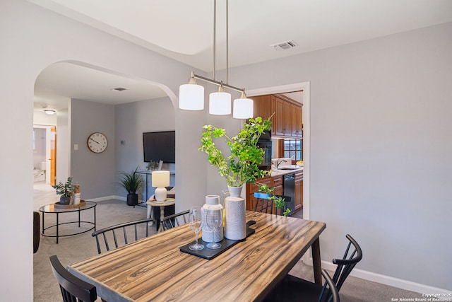 dining room featuring sink and carpet