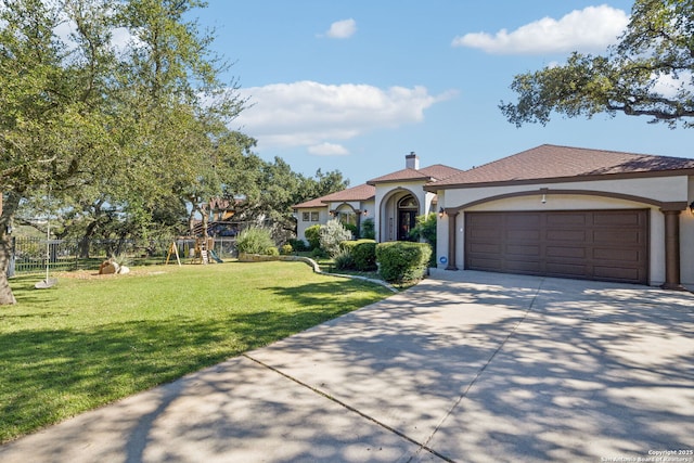 mediterranean / spanish home featuring a playground, a garage, and a front lawn