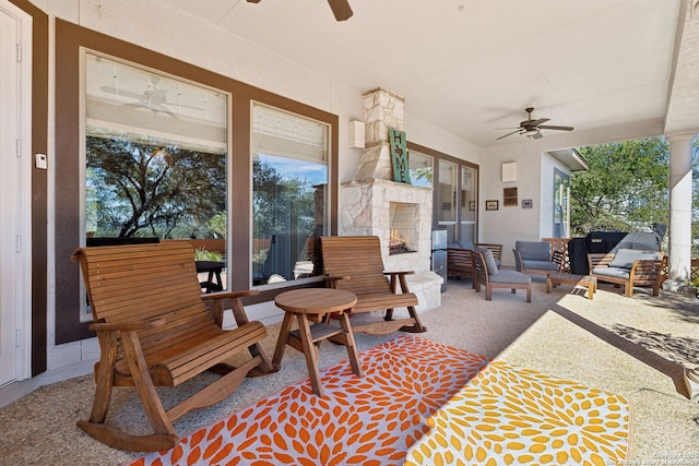 view of patio with an outdoor living space with a fireplace and ceiling fan