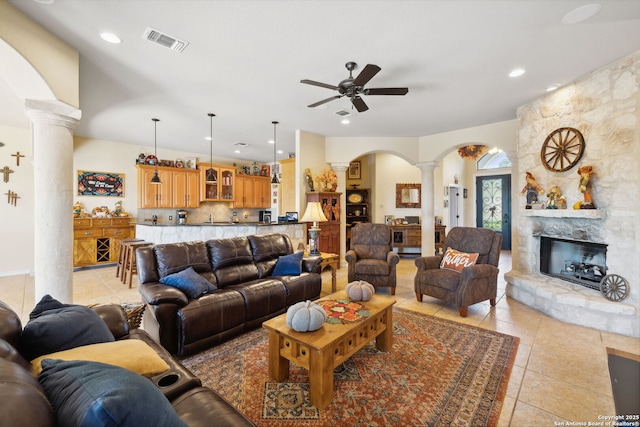 living room with ornate columns, ceiling fan, light tile patterned floors, and a fireplace