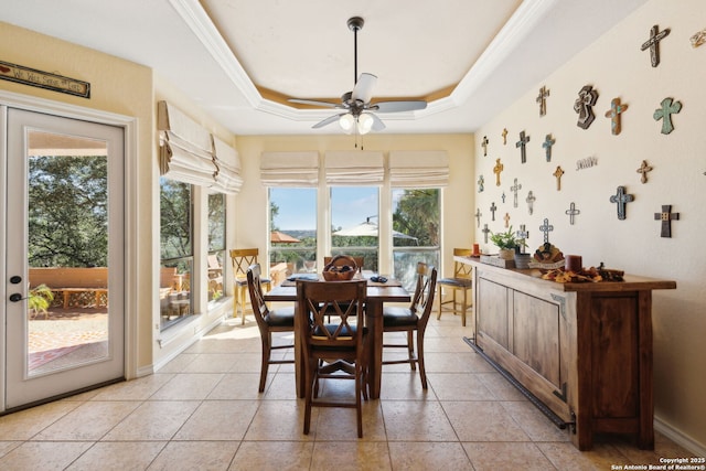 tiled dining area with crown molding, ceiling fan, and a tray ceiling