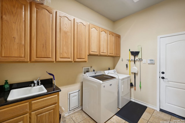 clothes washing area with light tile patterned flooring, cabinets, sink, and washing machine and clothes dryer