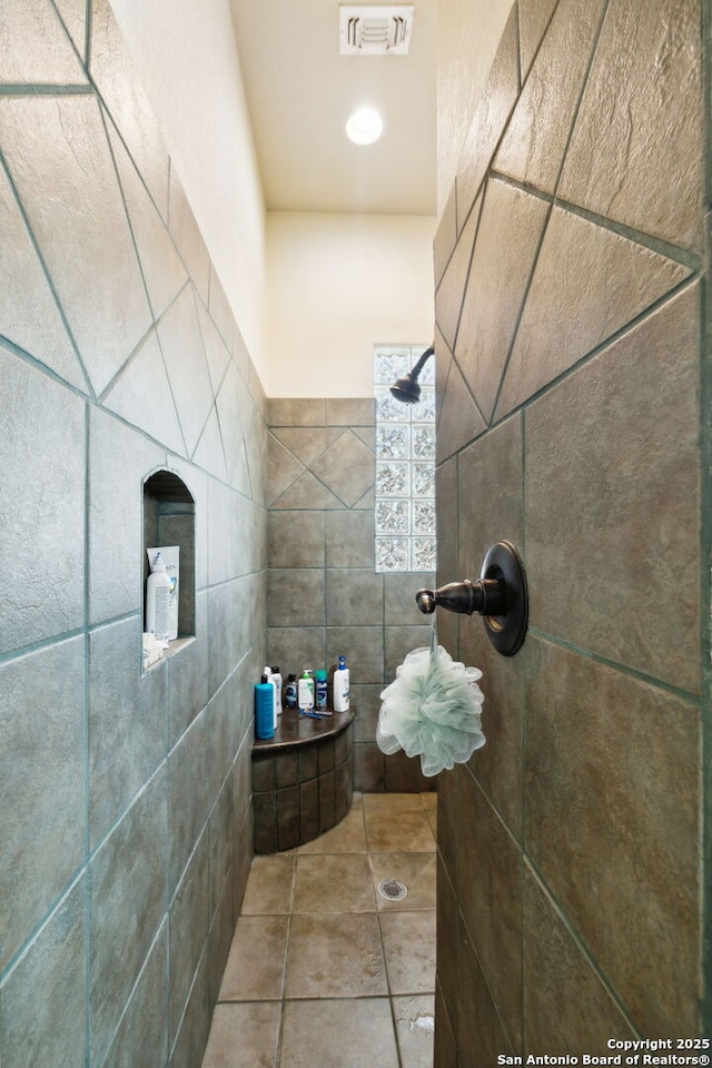 bathroom with walk in shower, tile patterned flooring, and tile walls