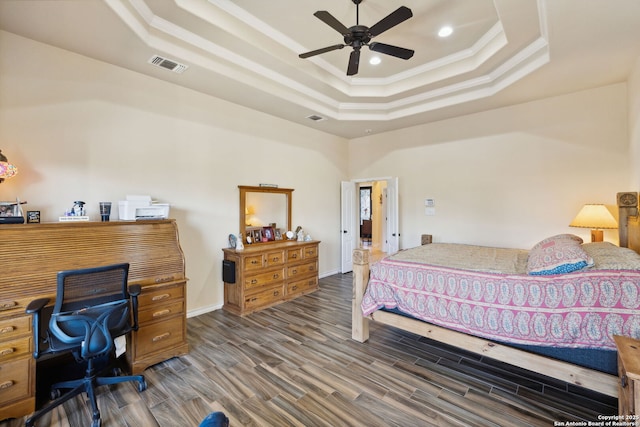 bedroom featuring a raised ceiling, ornamental molding, hardwood / wood-style floors, and ceiling fan