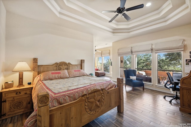 bedroom featuring ceiling fan, dark hardwood / wood-style floors, a tray ceiling, ornamental molding, and access to outside