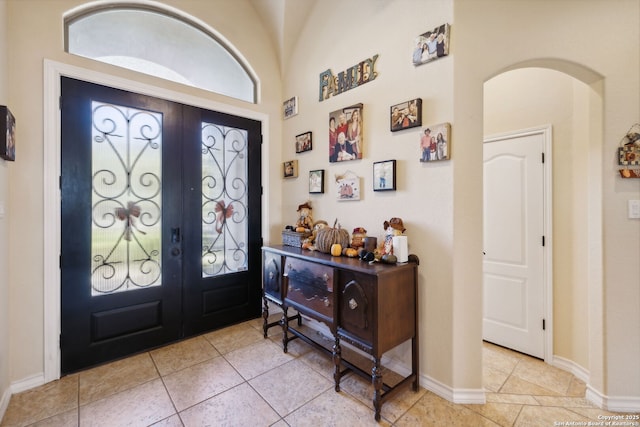 entryway with light tile patterned flooring and french doors