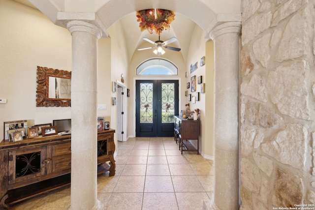 tiled foyer entrance with vaulted ceiling, french doors, ceiling fan, and ornate columns