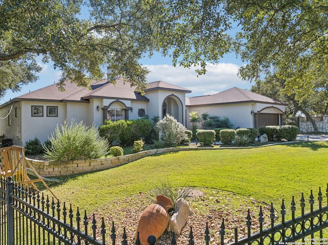 view of front of house featuring a garage and a front lawn