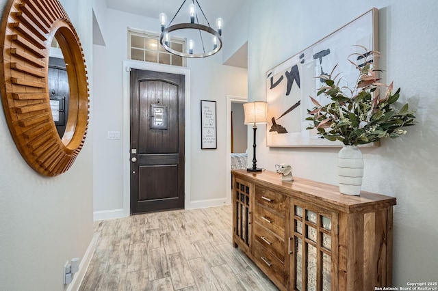 entryway featuring light hardwood / wood-style floors and a chandelier