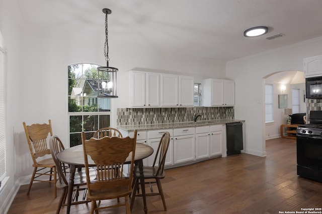 kitchen featuring pendant lighting, black appliances, white cabinets, dark hardwood / wood-style flooring, and decorative backsplash