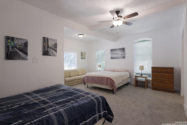 bedroom with ceiling fan, carpet flooring, beam ceiling, and a textured ceiling