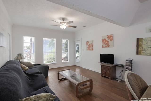 living room with ceiling fan, dark wood-type flooring, and a textured ceiling