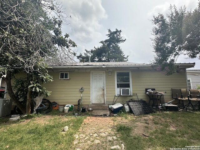 back of house with cooling unit, central AC, and a lawn