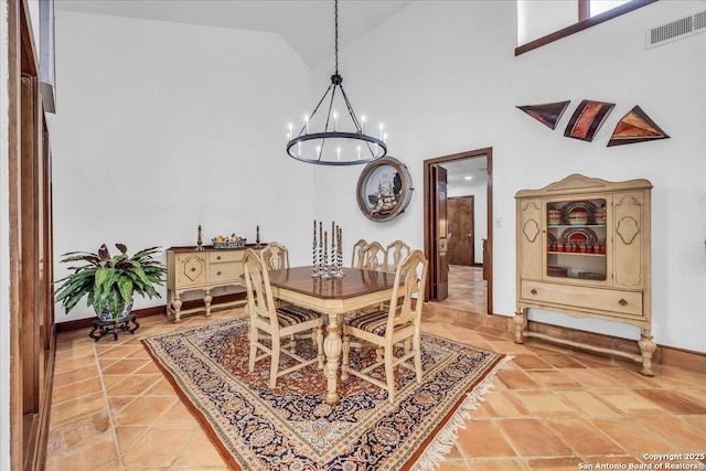 dining room with high vaulted ceiling, tile patterned floors, and a chandelier