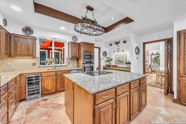 kitchen featuring pendant lighting, appliances with stainless steel finishes, beverage cooler, and a center island