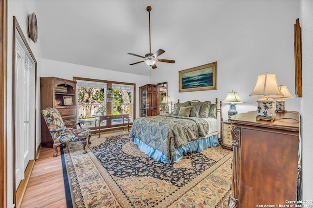 bedroom with ceiling fan, lofted ceiling, and light hardwood / wood-style flooring