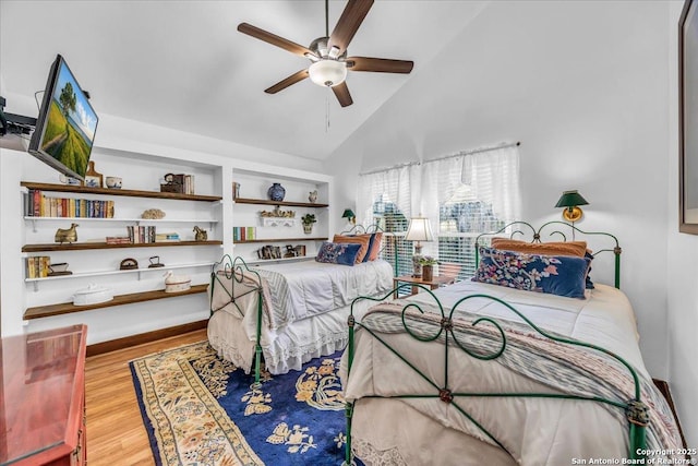 bedroom with ceiling fan, wood-type flooring, and high vaulted ceiling