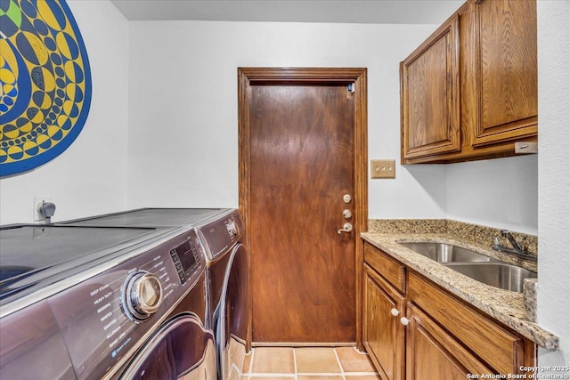 washroom featuring light tile patterned flooring, cabinets, sink, and washer and dryer