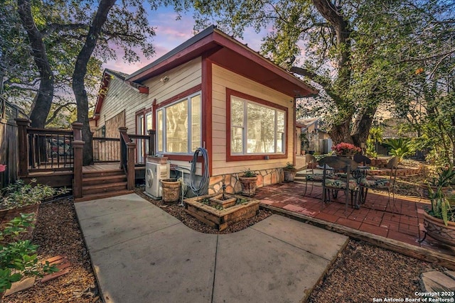 exterior space with a deck, a patio, and ac unit