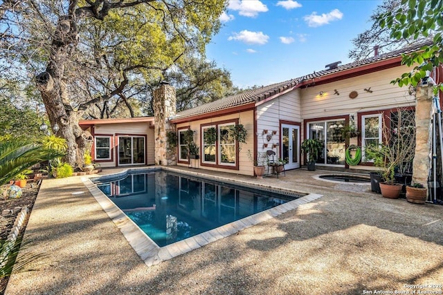 view of pool with a jacuzzi and a patio