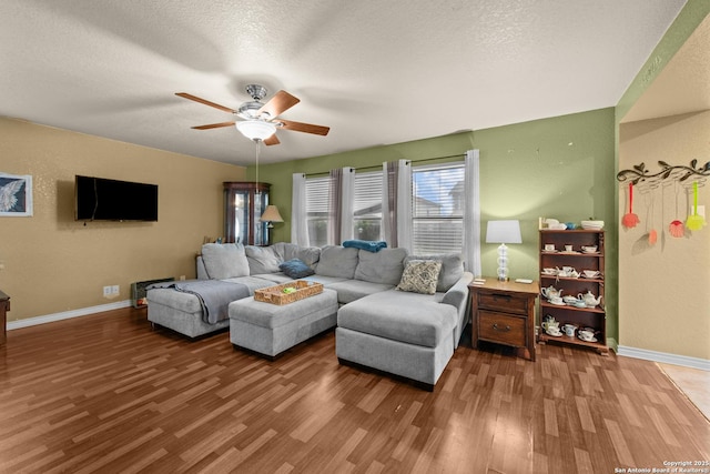 living room featuring hardwood / wood-style floors, a textured ceiling, and ceiling fan