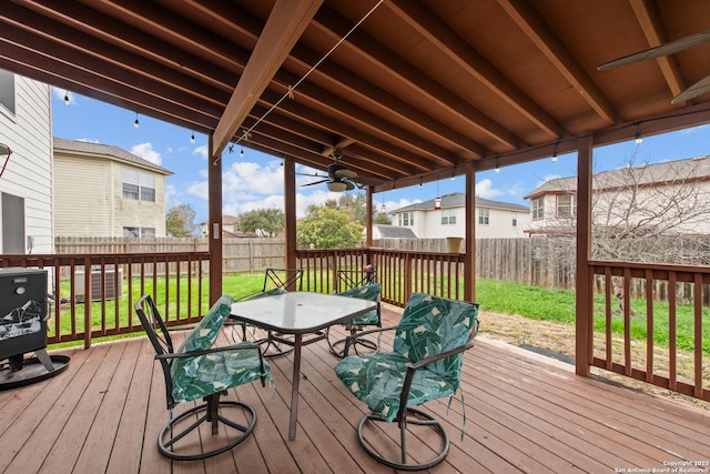 wooden terrace with ceiling fan and a yard