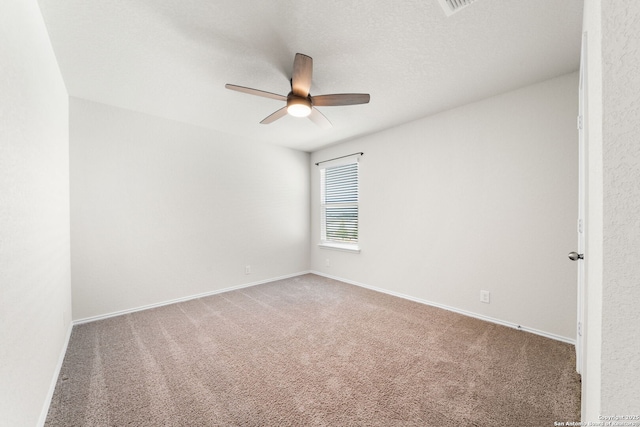 carpeted empty room featuring ceiling fan and a textured ceiling