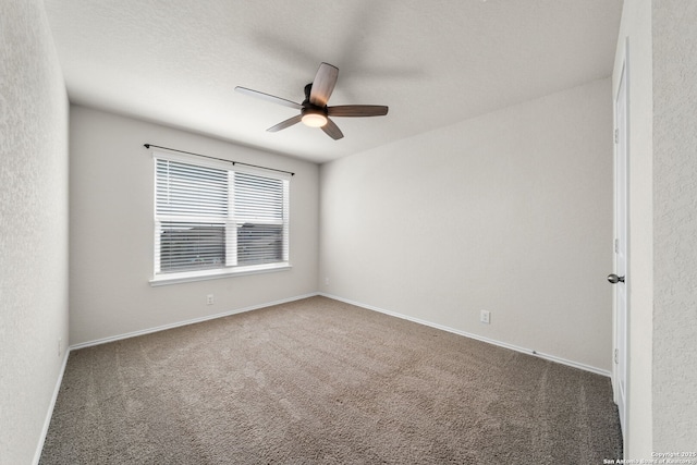 unfurnished room with dark carpet and ceiling fan