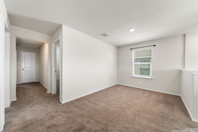 carpeted empty room featuring a textured ceiling