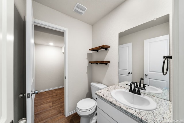 bathroom featuring vanity, toilet, and hardwood / wood-style floors