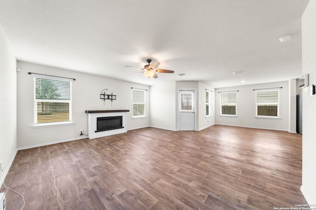 unfurnished living room featuring hardwood / wood-style flooring, a textured ceiling, and ceiling fan