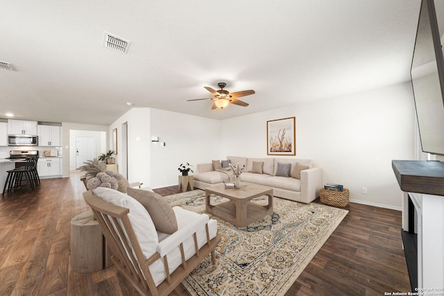 living room featuring dark hardwood / wood-style floors and ceiling fan