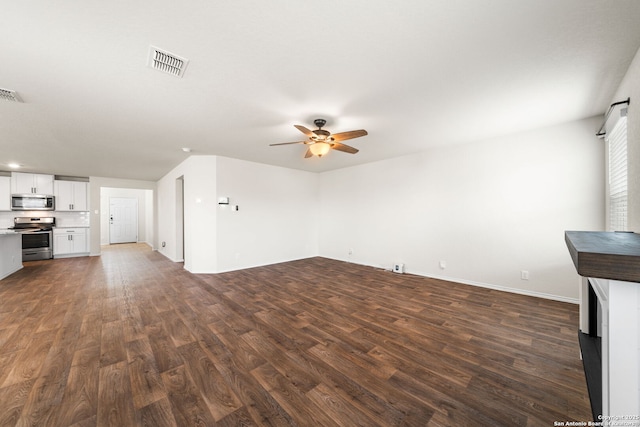 unfurnished living room featuring ceiling fan and dark hardwood / wood-style floors