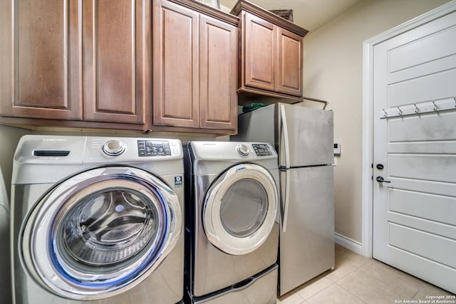 laundry area with cabinets, light tile patterned flooring, and separate washer and dryer