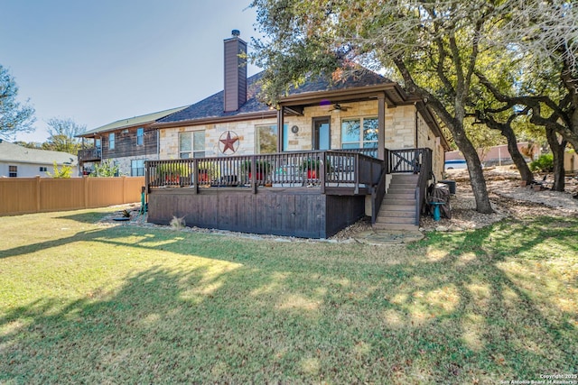 back of house featuring a lawn and a deck