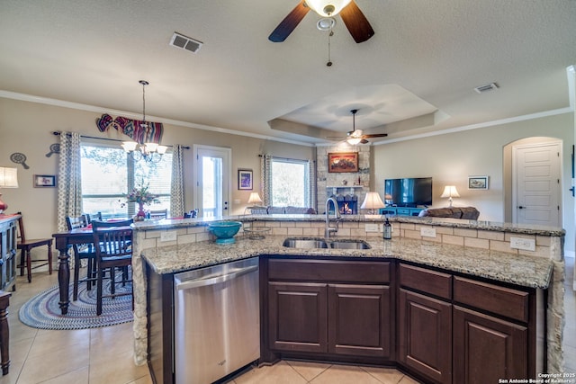 kitchen featuring pendant lighting, dishwasher, sink, a raised ceiling, and dark brown cabinets