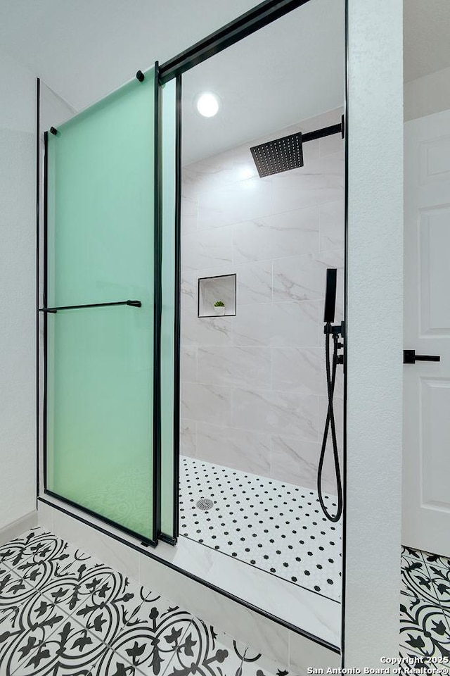 bathroom featuring a tile shower and tile patterned floors