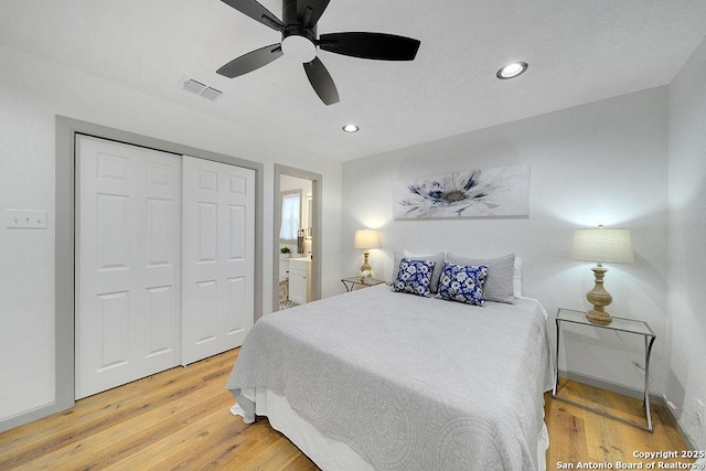 bedroom with ensuite bath, wood-type flooring, a closet, and ceiling fan