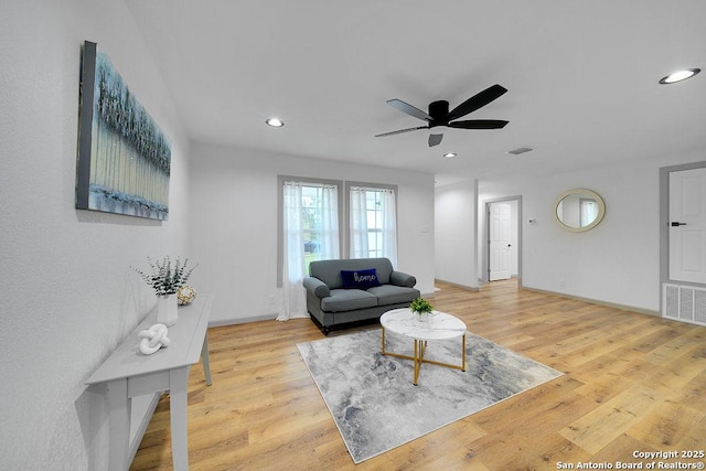 living room with light hardwood / wood-style floors and ceiling fan