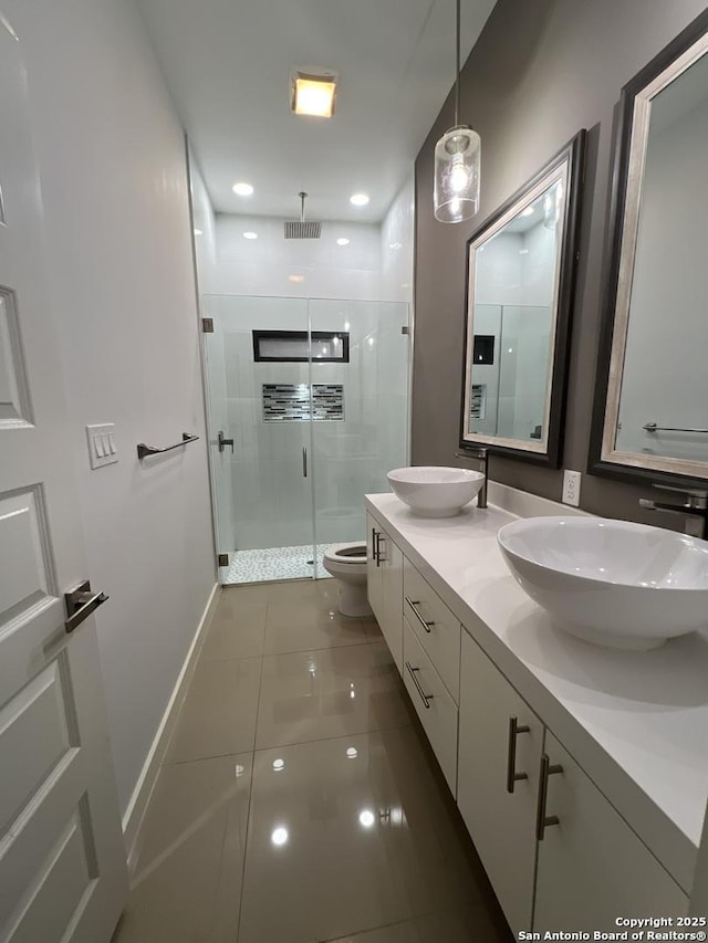 bathroom featuring a shower with door, vanity, tile patterned floors, and toilet