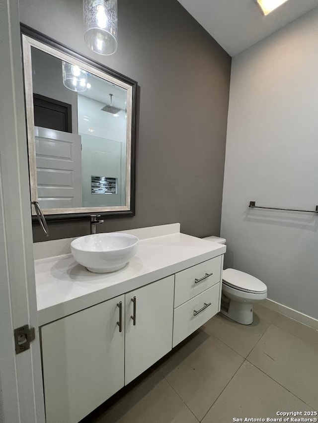 bathroom featuring tile patterned flooring, vanity, and toilet