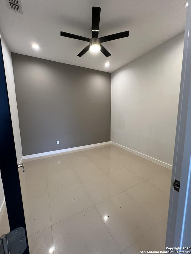 spare room featuring tile patterned floors and ceiling fan