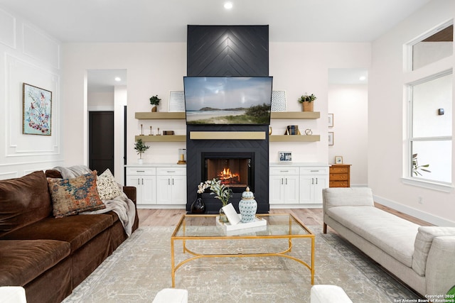 living room featuring a fireplace and light wood-type flooring