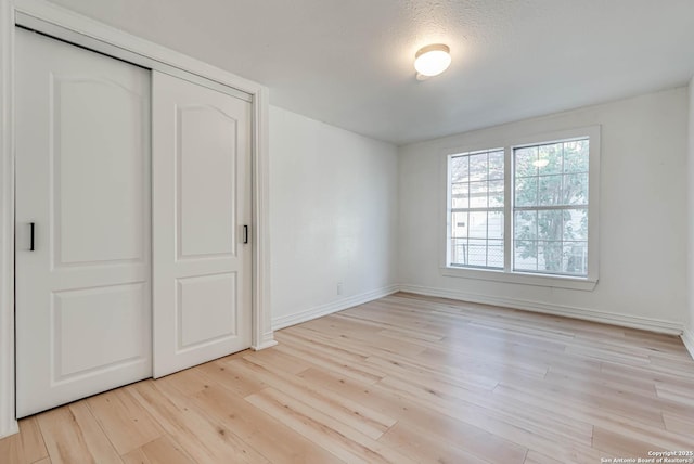 unfurnished bedroom with light hardwood / wood-style floors and a closet