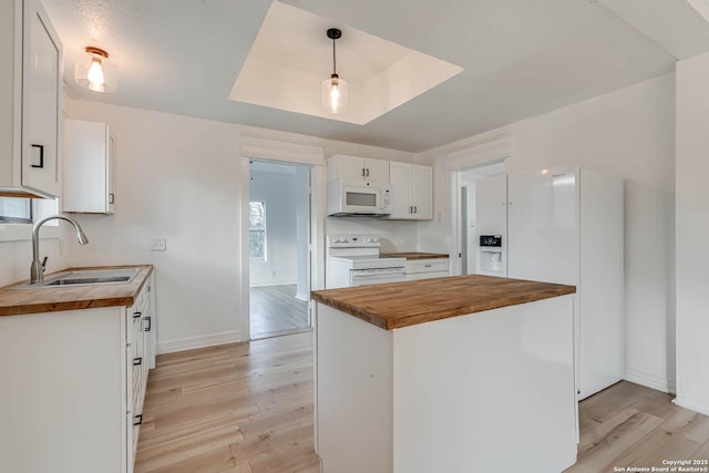 kitchen featuring white cabinetry, white appliances, decorative light fixtures, and butcher block countertops