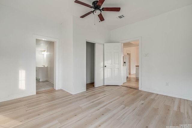 unfurnished bedroom featuring a closet, connected bathroom, ceiling fan, and light hardwood / wood-style flooring