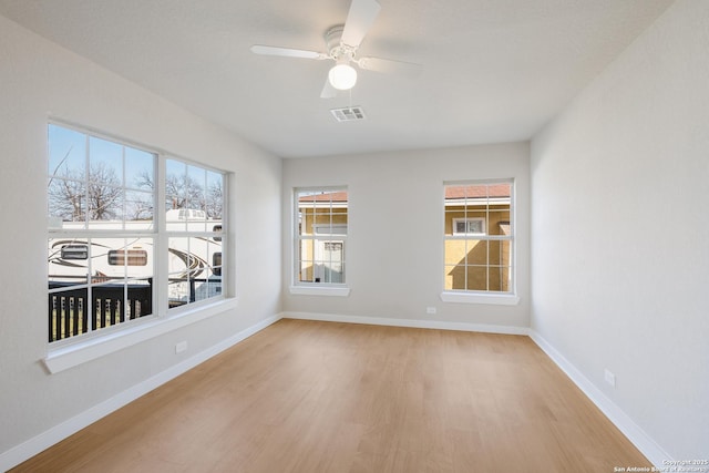 empty room with ceiling fan and light hardwood / wood-style floors