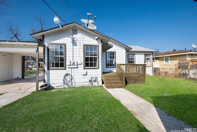 bungalow featuring a carport, a wooden deck, and a front yard