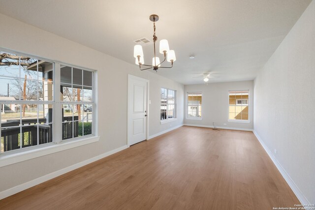 interior space featuring ceiling fan with notable chandelier, hardwood / wood-style floors, and a wealth of natural light